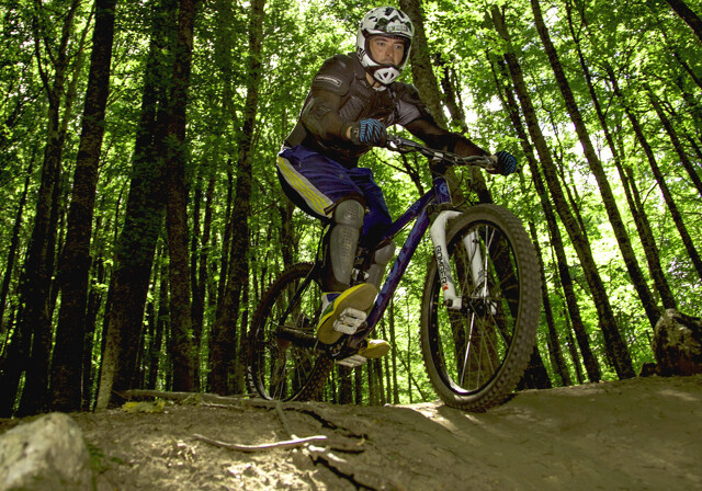 Mand på mountainbike i skoven